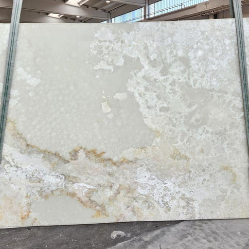 Onyx Bianco plade — translucent hvid og lysegrøn baggrund med organiske blomsterlignende mønstre i hvid og lysegul poleret finish