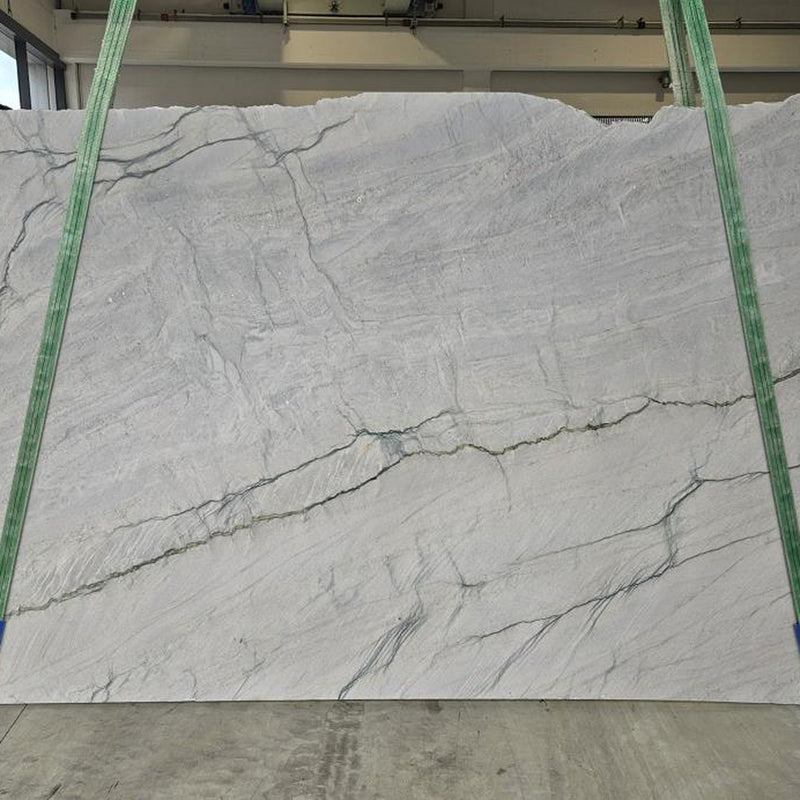 Meridina quartziteplade — ren hvid baggrund med subtile grå horisontale årer og diskrete grønlige strejf poleret finish