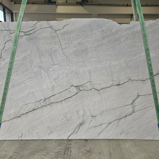Meridina quartziteplade — ren hvid baggrund med subtile grå horisontale årer og diskrete grønlige strejf poleret finish