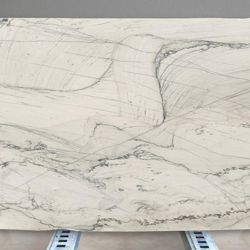 Opus White quartziteplade — cremehvid baggrund med abstrakte grå-grønne organiske flydende årer poleret finish