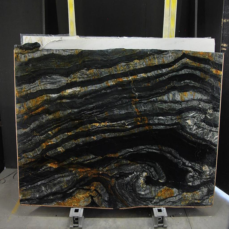 Calacatta Macchia Black quartziteplade — dyb sort baggrund med bølgende horisontale lag i sølv og gyldenbrun poleret finish