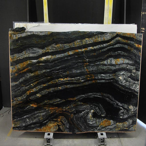 Calacatta Macchia Black quartziteplade — dyb sort baggrund med bølgende horisontale lag i sølv og gyldenbrun poleret finish