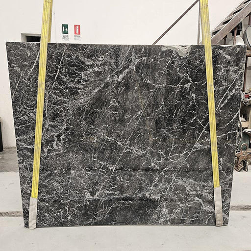 Grigio Carnico marmorplade — dyb mørkegrå baggrund med fint netværk af hvide årer poleret finish