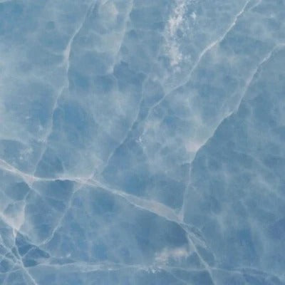 Onyx Blue natursten flise — ren azurblå baggrund med fine hvide krystallinske årer som frosne vandstrømme