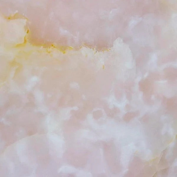 Onyx Rosa natursten flise — blød lyserosa og cremehvid baggrund med delikate gyldne diagonale årer