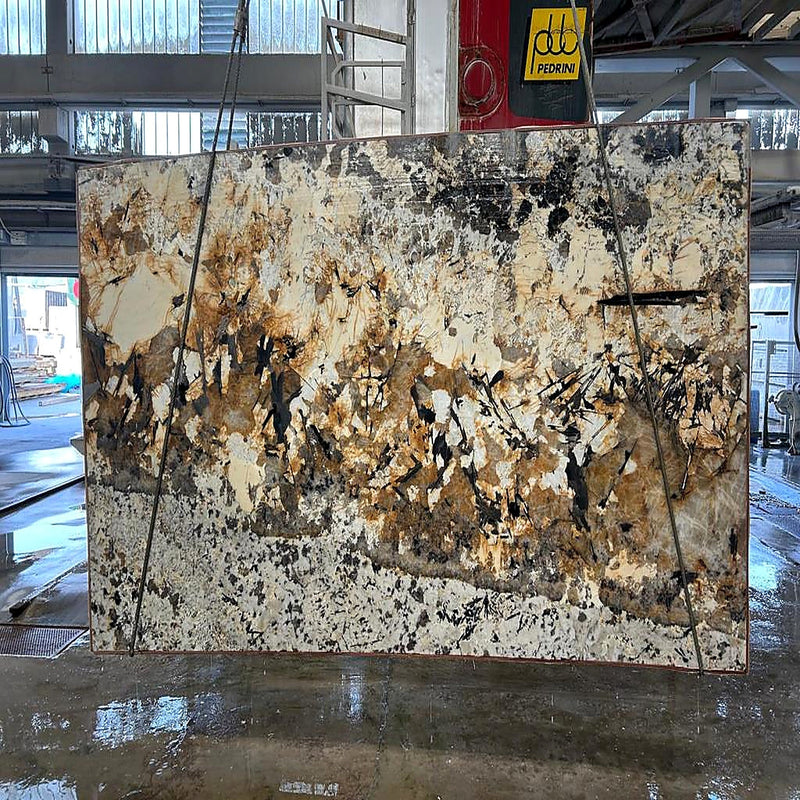 Patagonia Quartzite marmorplade — lys cremehvid baggrund med dramatiske gyldenbrune og sorte fragmenter poleret finish
