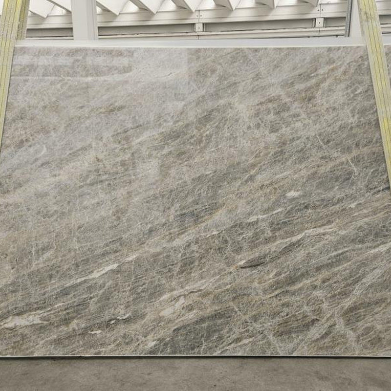 Cielo quartziteplade — blød grå-sølv baggrund med fine diagonale skyformede årer poleret finish
