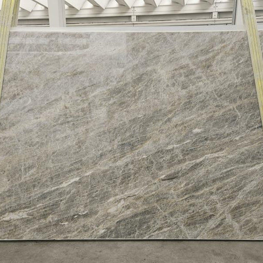 Cielo quartziteplade — blød grå-sølv baggrund med fine diagonale skyformede årer poleret finish